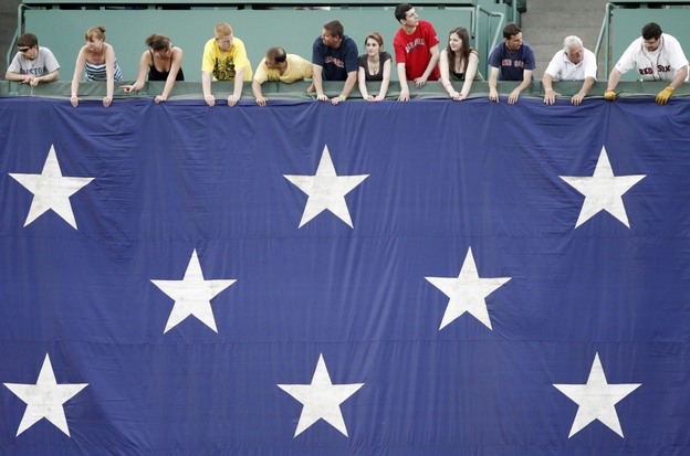 Boston Red Sox fans hold a large American flag before a game on Monday.
