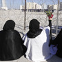 Bahraini protesters hold up flowers toward riot police near the Pearl Roundabout in February. On March 18, the government demolished the monument, which had become a prominent gathering place for opposition protesters.