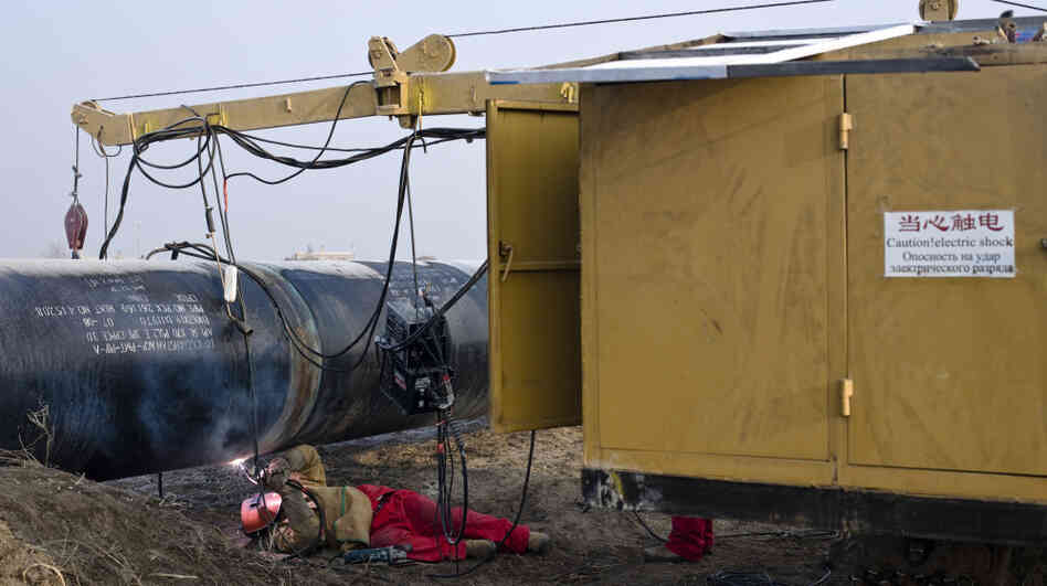 A worker welds at the China-Kazakhstan pipeline junction in Xinjiang, China, in 2008. A worker welds at the China-Kazakhstan pipeline junction in Xinjiang, China, in 2008.