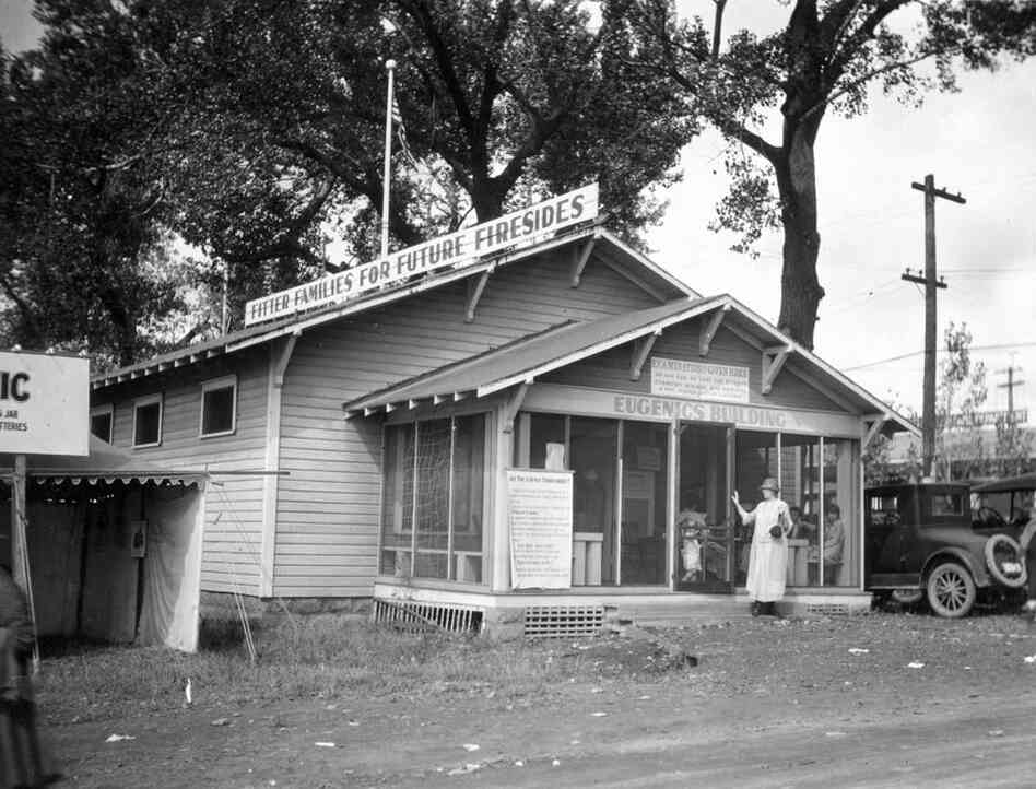 An exhibit and examination building is marked with a sign: "Fitter Families for Future Firesides."