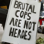 At a rally in Chicago in 2004, demonstrators display a sign that reads 'Brutal Cops Are Not Heroes."