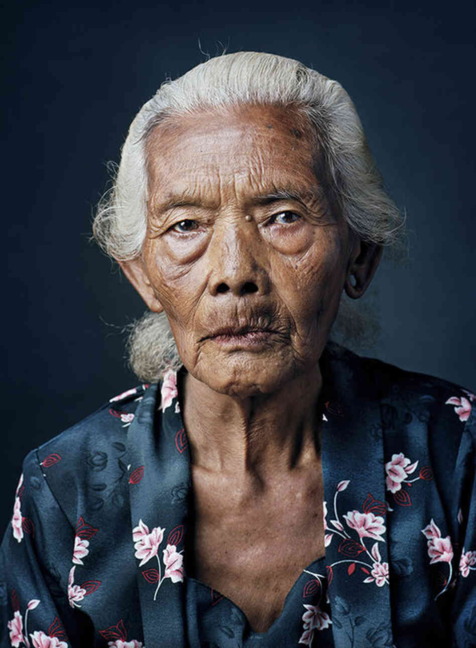 Kasinem, born 1931, Kemuning, Central JavaAt age 13, Kasinem received the Japanese name 'Kanaku' and had to service three or four men every day. In the brothel, where another 30 women were kept, too, each had her own room. Years later she married and started a family of six children. She now lives with grandchildren and great-grandchildren and works in the rice fields behind the house.