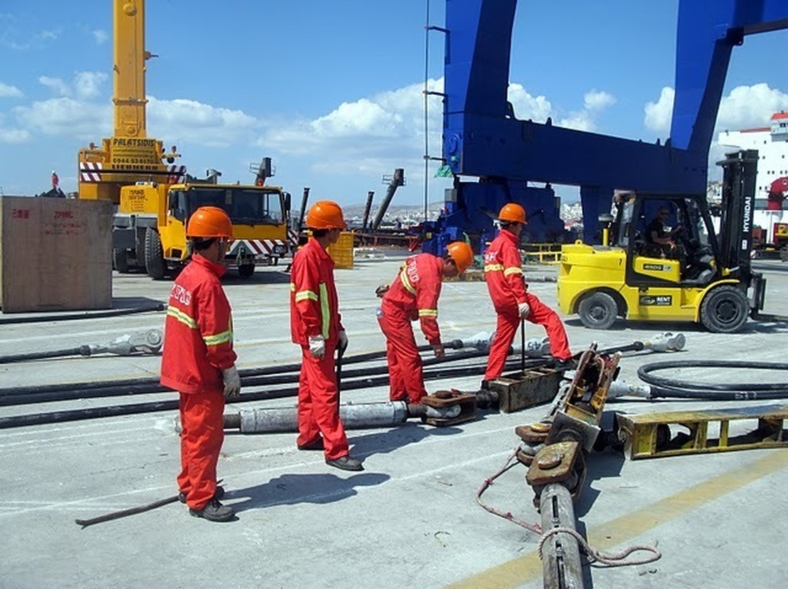Employees of China's state-run Cosco company work at the port in Greece on Sept. 13, 2010. The company is accused by Greek unionists and by employees of importing Chinese labor practices.