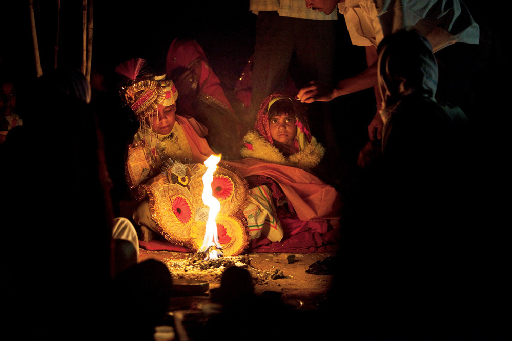 Rajani and her boy groom barely look at each other as they are married in front of the sacred fire. By tradition, the young bride is expected to live at home until puberty, when a second ceremony transfers her to her husband.