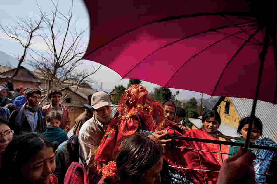 Although early marriage is the norm in her small Nepali village, 16-year-old Surita wails in protest as she leaves her family's home, shielded by a traditional wedding umbrella and carried in a cart to her new husband's village.