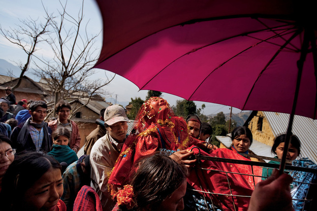 Although early marriage is the norm in her small Nepali village, 16-year-old Surita wails in protest as she leaves her family's home, shielded by a traditional wedding umbrella and carried in a cart to her new husband's village.