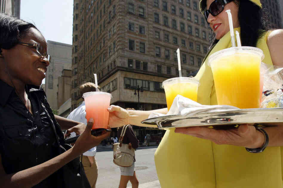 Stephanie Guerilus buys a cold lemonade in the hot Philadelphia sun from Lisa Tobin, who surely is sweltering in her lemon costume. 