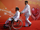 A man pushes a friend in a wheelchair following an event in Beijing to raise awareness of accessibility issues for the disabled. A man pushes a friend in a wheelchair following an event in Beijing to raise awareness of accessibility issues for the disabled.