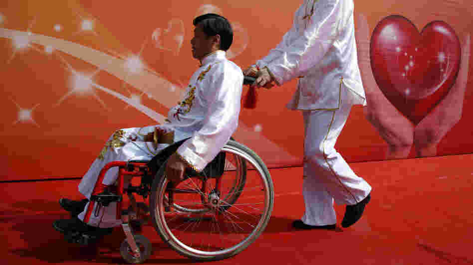 A man pushes a friend in a wheelchair following an event in Beijing to raise awareness of accessibility issues for the disabled. A man pushes a friend in a wheelchair following an event in Beijing to raise awareness of accessibility issues for the disabled.