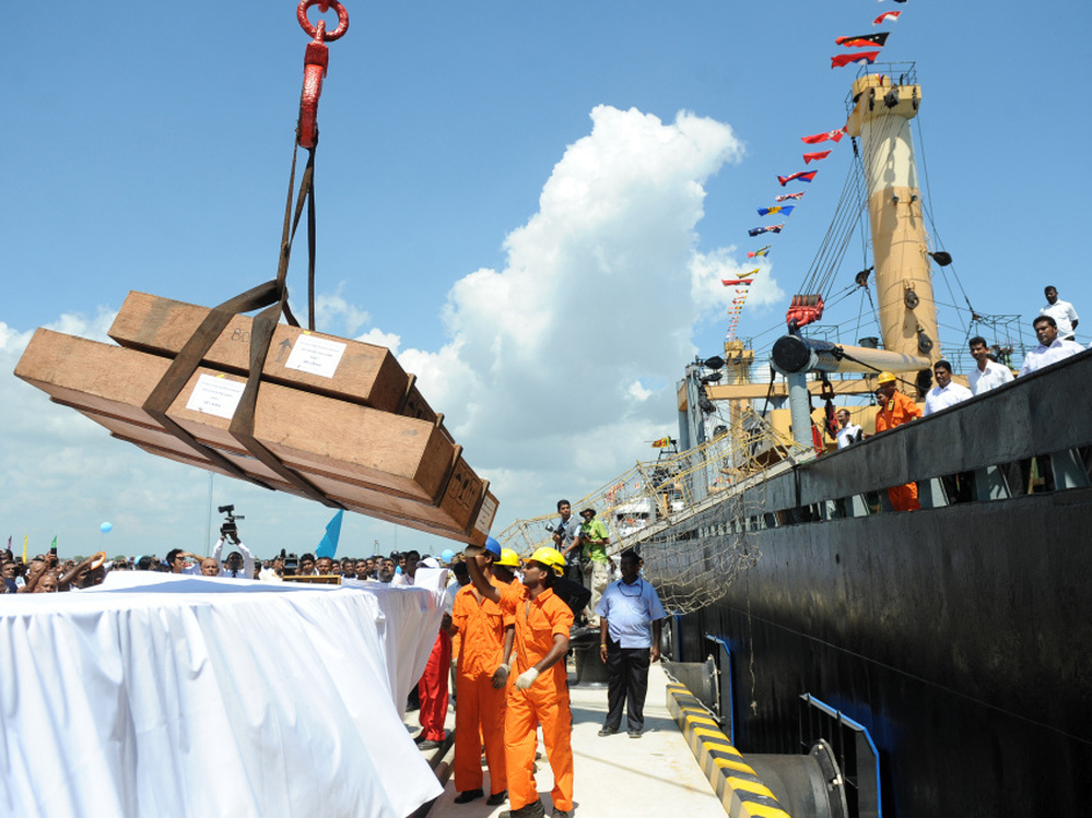 Workers unload cargo from the first vessel to enter the Chinese-funded port in Hambantota, Sri Lanka, in November 2010. China's Export-Import Bank provided 85 percent of the financing for construction of the port.