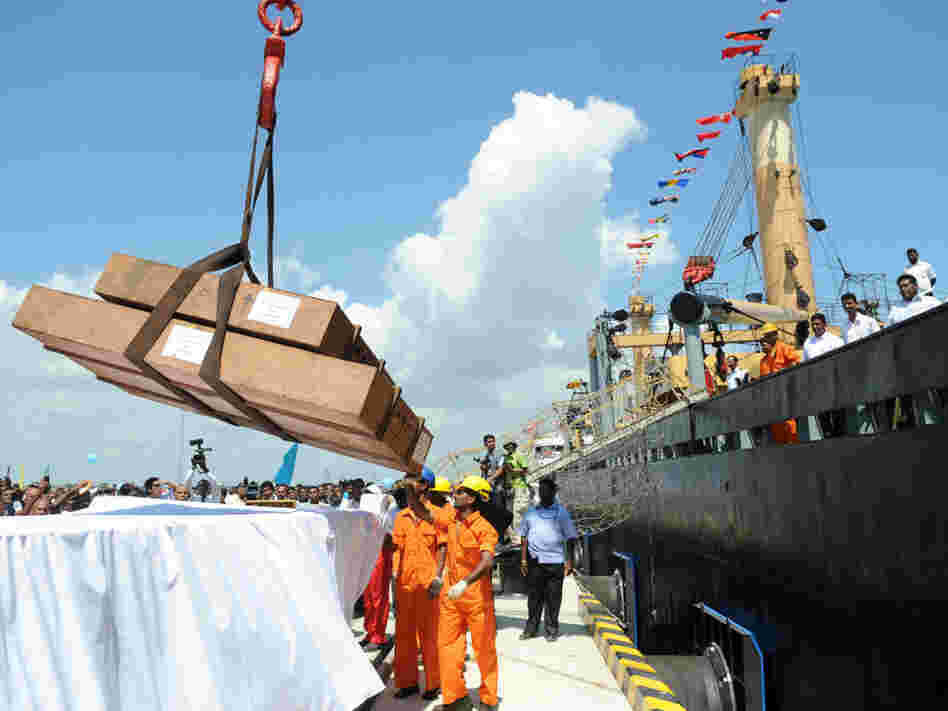 Workers unload cargo from the first vessel to enter the Chinese-funded port in Hambantota, Sri Lanka, in November 2010. China's Export-Import Bank provided 85 percent of the financing for construction of the port.