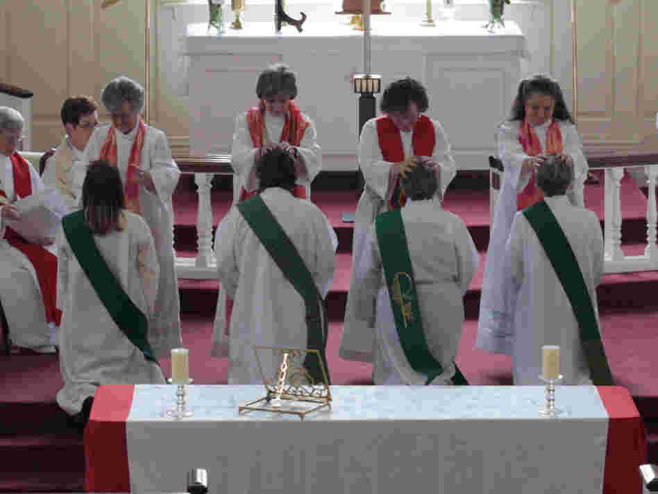 In the "laying on of hands" during the ordination ceremony, the priests place their hands on the candidates before they are officially ordained. The future priests are (from left): Ann Penick, Marellen Mayers, Patricia "Patti" LaRosa and  Caryl Johnson.