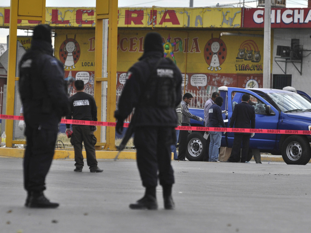 Federal police patrol a scene where two investigative police officers were shot by unidentified assailants in Juarez in December.