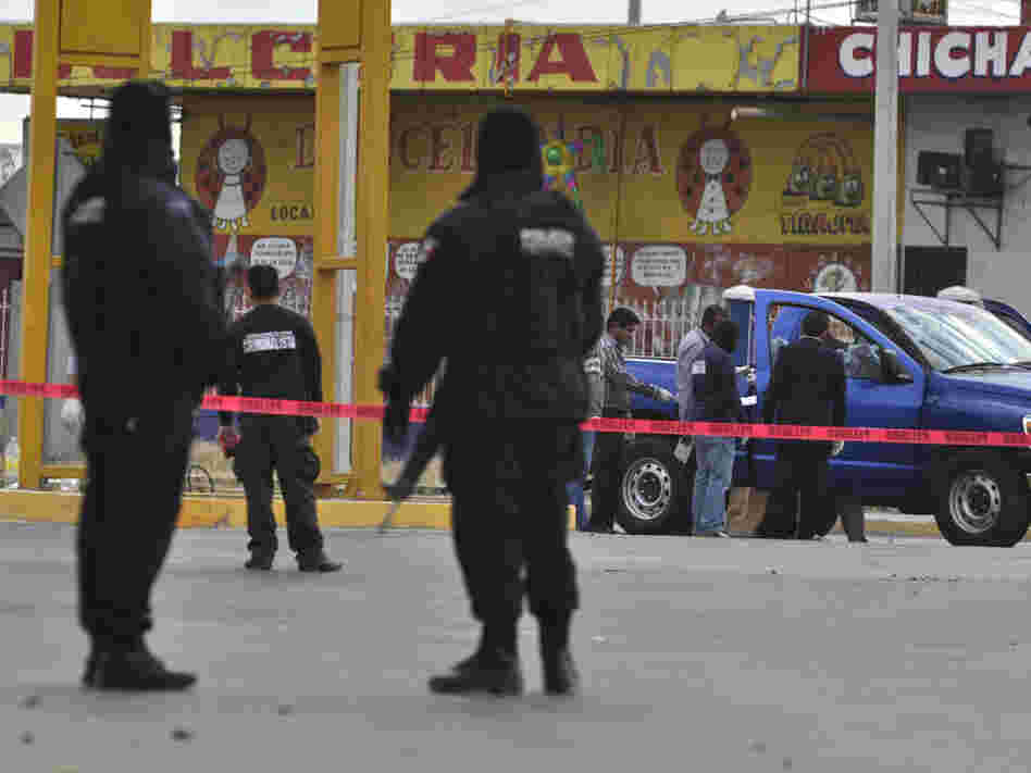 Federal police patrol a scene where two investigative police officers were shot by unidentified assailants in Juarez in December.