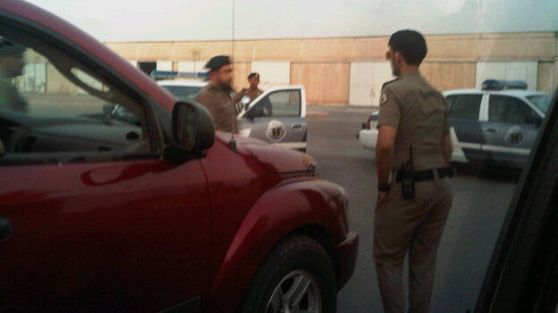 Saudi policemen surrounding the cars of women who drove. (@Maysa_M)