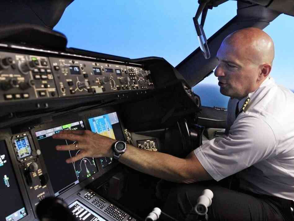 Pilot Gregg Pointon shows off the cockpit of a Boeing 787 flight simulator. GPS navigation is the basis for a new air traffic control system the government plans to build, but a company's plan to expand broadband Internet could interfere with GPS signals.