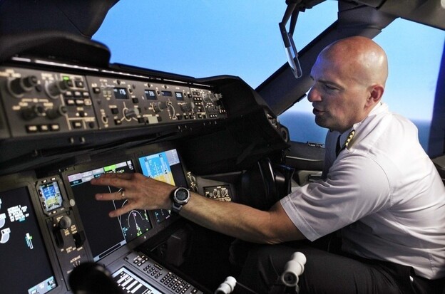 Pilot Gregg Pointon shows off the cockpit of a Boeing 787 flight simulator. GPS navigation is the basis for a new air traffic control system the government plans to build, but a company's plan to expand broadband Internet could interfere with GPS signals.
