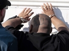 U.S. Marshals deputies restrain a suspected member of an Azusa, Calif., gang after a raid in Irwindale on June 7. The Latino gang conspired to rid the Southern California city of its black residents through threats and violence dating back to the early 1990s, according to an indictment. U.S. Marshals deputies restrain a suspected member of an Azusa, Calif., gang after a raid in Irwindale on June 7. The Latino gang conspired to rid the Southern California city of its black residents through threats and violence dating back to the early 1990s, according to an indictment.