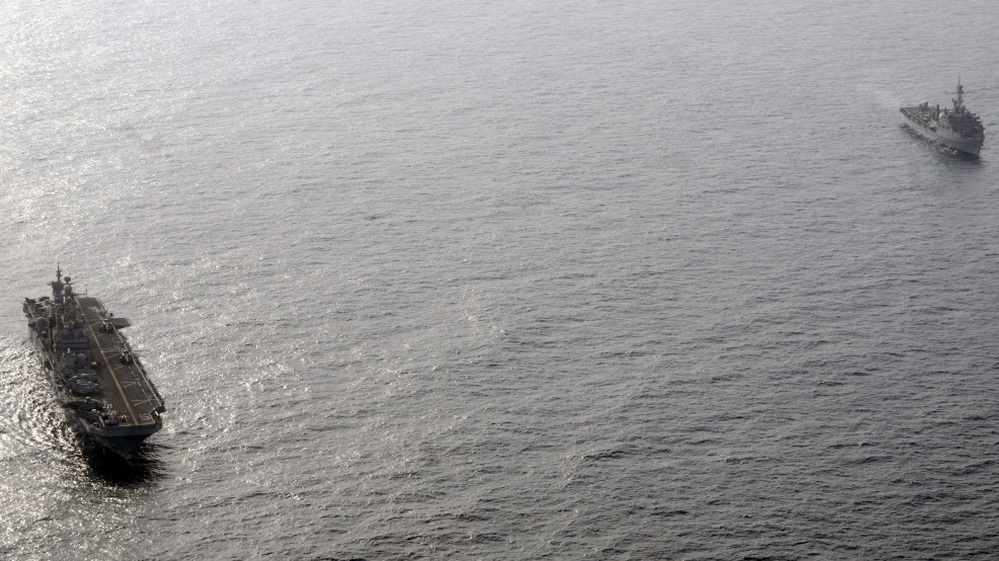 The amphibious assault ship USS Peleliu (L) and the amphibious transport dock ship USS Dubuque in the Arabian Sea off the coast of Pakistan.