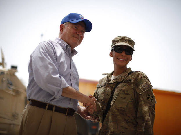 U.S. Secretary of Defense Robert Gates, wearing a baseball cap, shakes hands with a female soldier, wearing a patrol cap, at Forward Operating Base Walton in Kandahar province, Afghanistan.