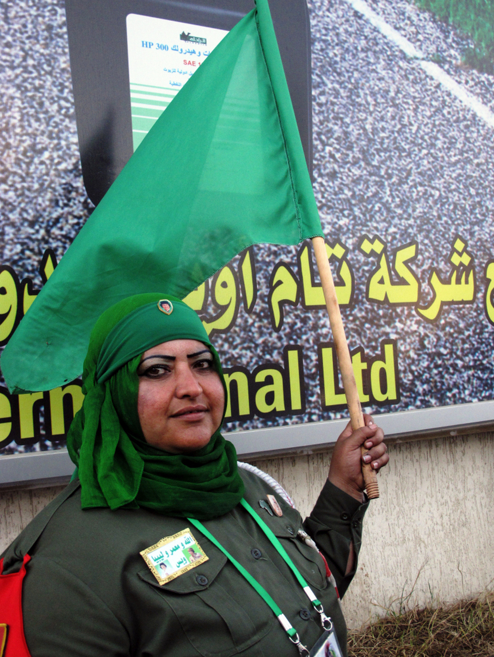 Volunteer Ibtisam Saadeddin, who wears a khaki uniform and a badge and pins with photos of Moammar Gadhafi, says she patrols the line at the women-only gas station to make sure no fights break out.
