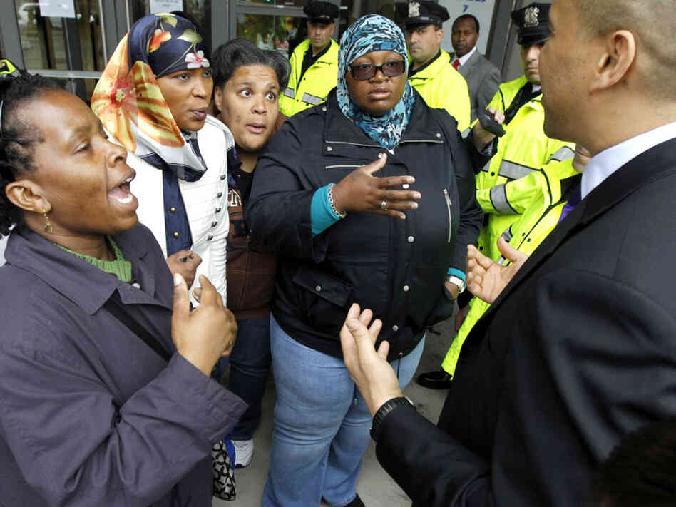 Newark Mayor Cory Booker, right, talks to community organizers after announcement of the Newark Public School chief in May. The organizers asked the mayor why the community wasn't invited to participate in the selection process.