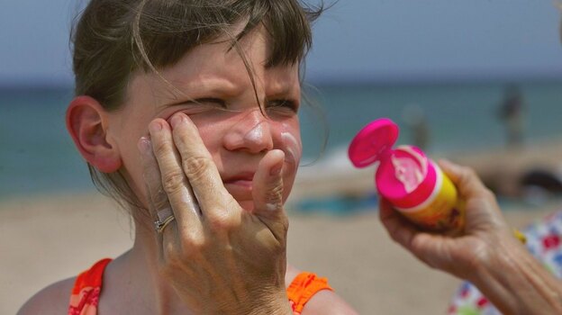 Savannah Stidham gets smeared with sunscreen during a visit to a beach in Fort Lauderdale, Fla., in 2006.