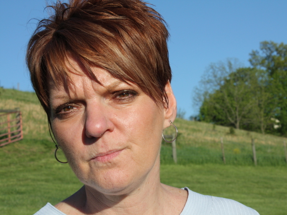 Pam Judy stands in the yard of her home in southwest Pennsylvania. Members of her family say they have been affected by unhealthy air quality, which might be connected to natural gas fumes from a compressor 700 feet from their house.
