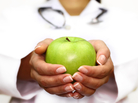 A female doctor holds an apple in her hands. A female doctor holds an apple in her hands.