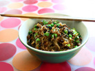 Chopsticks rest across a bowl of noodles on a placemat Chopsticks rest across a bowl of noodles on a placemat