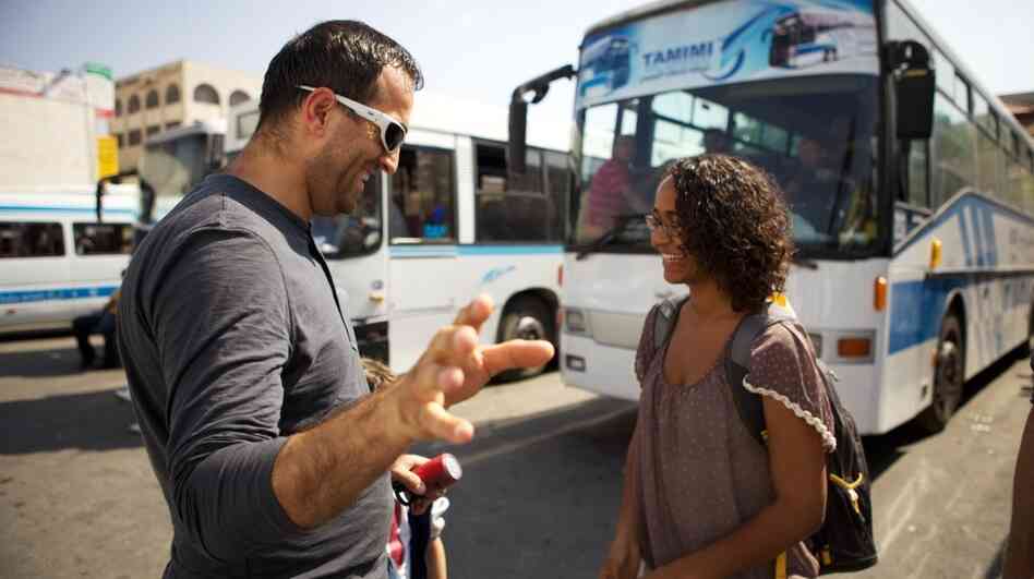 Palestinian artist Khaled Jarrar (left) has been stamping passports in advance of a possible Palestinian bid for recognition at the United Nations in September. His stamp is not a valid passport mark, but a statement in support of U.N. bid. Here, he stamps a tourist's passport at the Ramallah central bus station. Palestinian artist Khaled Jarrar (left) has been stamping passports in advance of a possible Palestinian bid for recognition at the United Nations in September. His stamp is not a valid passport mark, but a statement in support of U.N. bid. Here, he stamps a tourist's passport at the Ramallah central bus station.