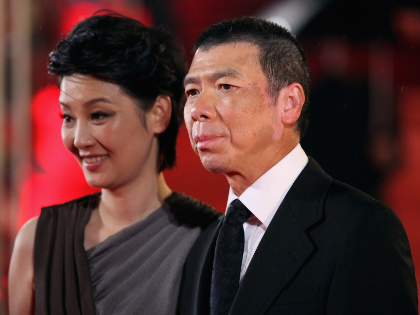 Director Feng Xiaogang, whose 2010 film Aftershock is China's highest-grossing Chinese-made film of all time, arrives at the 14th Shanghai International Film Festival. At left is his wife Xu Fan, who starred in Aftershock.