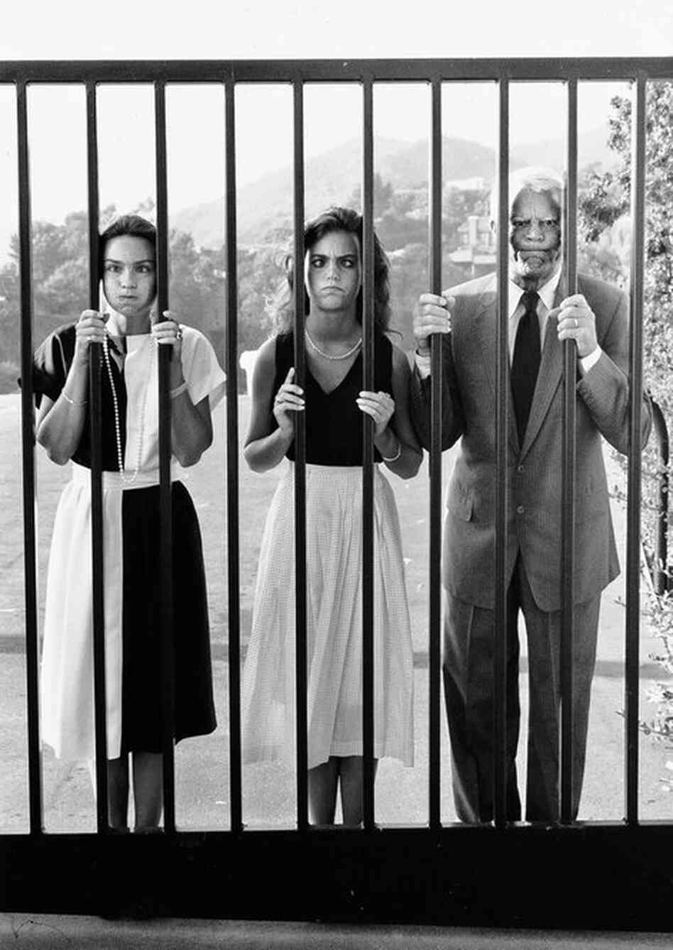 Barbara, Jennifer and Cary Grant make faces through the gate of their Beverly Hills home. 