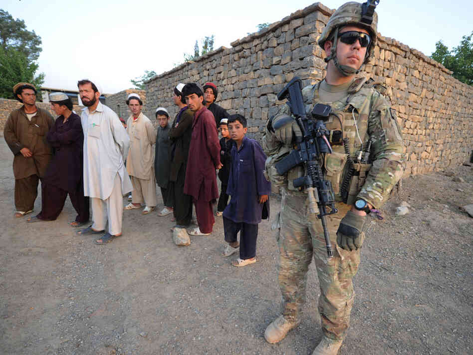 A US soldier of the Viper Company (Bravo), 1-26 Infantry, stands next to Afghans during a home to home search in the Sabari village, in the Khost province of eastern Afghanistan, on June 19, 2011. In our first hour, military experts talk about a possible time line for bringing troops home from Afghanistan. A US soldier of the Viper Company (Bravo), 1-26 Infantry, stands next to Afghans during a home to home search in the Sabari village, in the Khost province of eastern Afghanistan, on June 19, 2011. In our first hour, military experts talk about a possible time line for bringing troops home from Afghanistan.