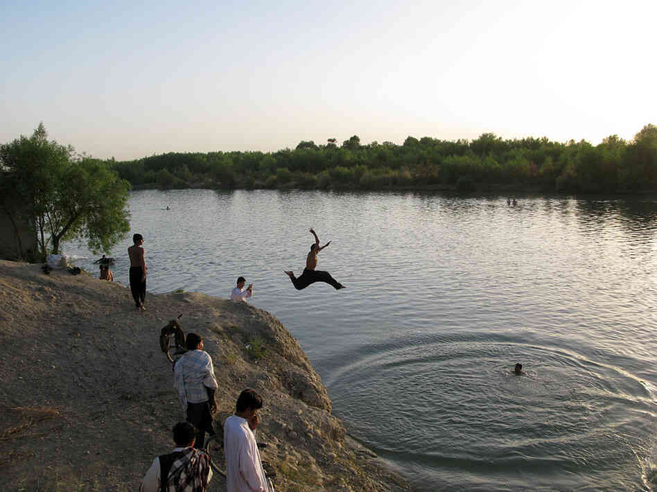 Men in Lashkar Gah jump into the Helmand River to beat the 120 degree heat of the Afghan summer. Men in Lashkar Gah jump into the Helmand River to beat the 120 degree heat of the Afghan summer.