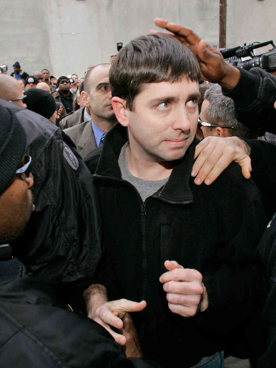 Michael Hunter Jr. shakes hands with a fellow officer in 2007 as he and six other New Orleans police officers turn themselves in.