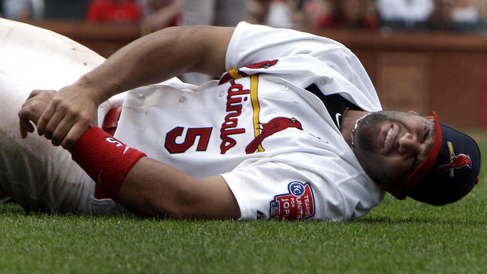 St. Louis Cardinals first baseman Albert Pujols grabs his left wrist after being injured on a play at first base during a game against the Kansas City Royals Sunday, June 19, 2011, in St. Louis.