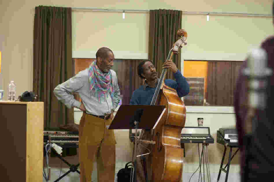 Ron Carter (left, as himself) looks on as Albert Lambreaux (Clarke Peters) attempts to show him a thing or two on bass, in Treme.
