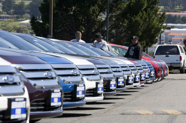 A salesman looks at Ford Fusion cars with customers on the lot at the Serramonte Ford dealership in Colma, Calif. This year, Ford Motor Co. reported its best first-quarter earnings since 1998, at $2.6 billion.