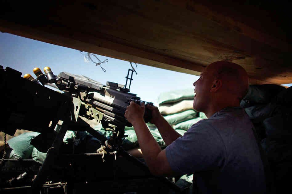 Specialist Gregory Goodrich, from Paw Paw Michigan, with Butcher Troop, part of the US Army 1st Infantry Division, fires a Mark 19 grenade launcher at a Taliban mortar team as incoming rounds were hitting just outside the bunker at Combat Outpost Wilderness in Paktia provence, eastern Afghanistan. Specialist Gregory Goodrich, from Paw Paw Michigan, with Butcher Troop, part of the US Army 1st Infantry Division, fires a Mark 19 grenade launcher at a Taliban mortar team as incoming rounds were hitting just outside the bunker at Combat Outpost Wilderness in Paktia provence, eastern Afghanistan.