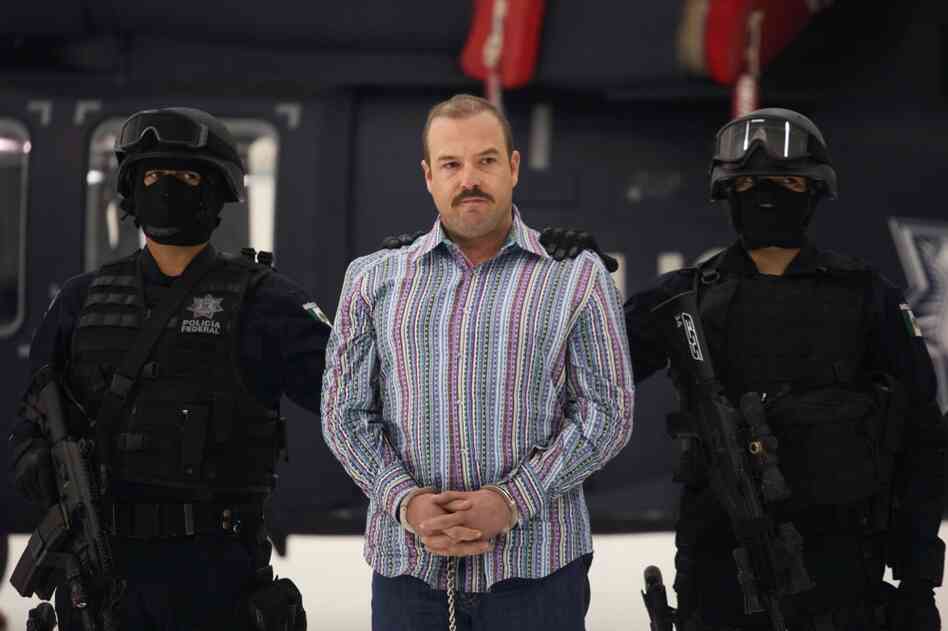 Captured Nov. 23, 2010: Carlos Montemayor, aka El Charro, or "The Cowboy," the alleged leader of the Beltran Leyva gang, appears with police officers a day after his arrest in Mexico City. 