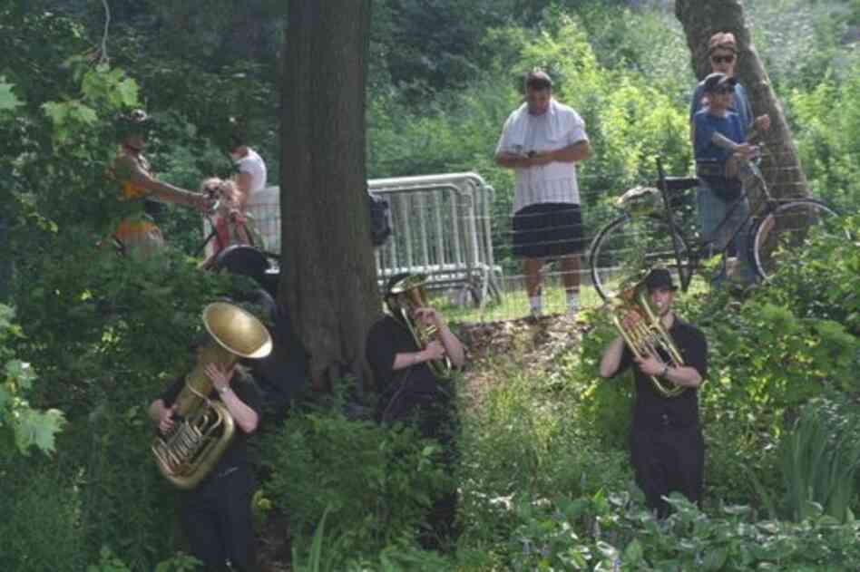 Park passers-by find three brass players springing out of the greenery along Central Park Lake during 'Swelter.'
