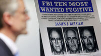 FBI special agent Richard Deslauriers speaks Monday during a news conference next to a poster featuring fugitive James