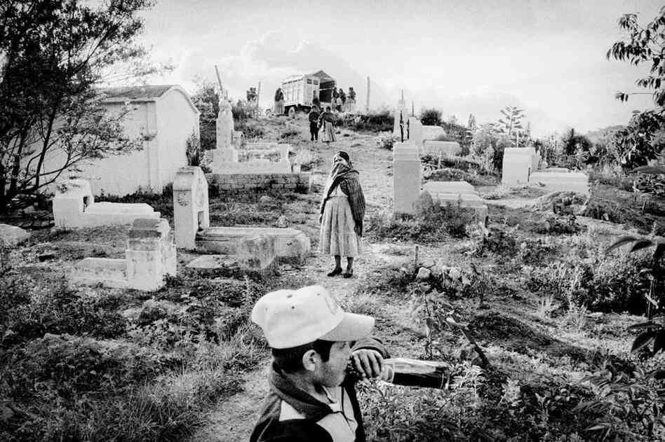 Residents await the start of a burial at the cemetery.