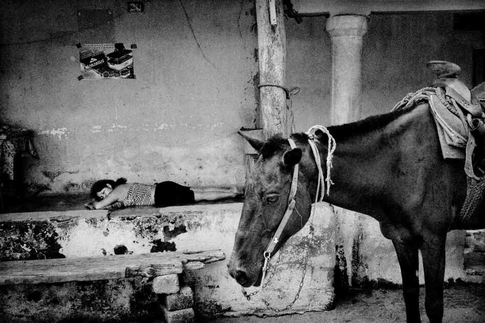 A woman rests on the patio of a village store.