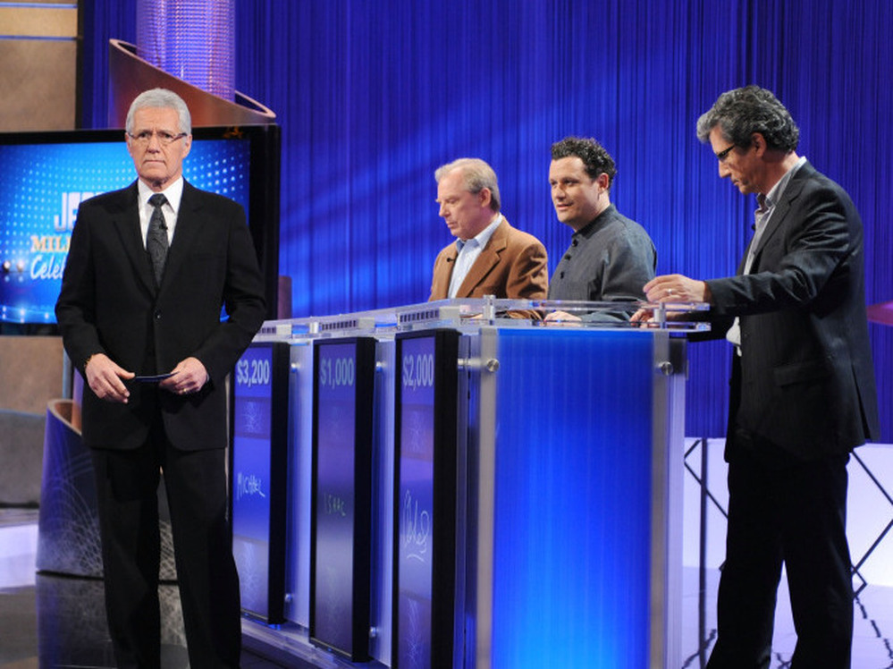 Host Alex Trebek greets celebrity contestants on the set of Jeopardy! For non-celebrity contestants, fame means a 30-second personal anecdote after the first commercial break.