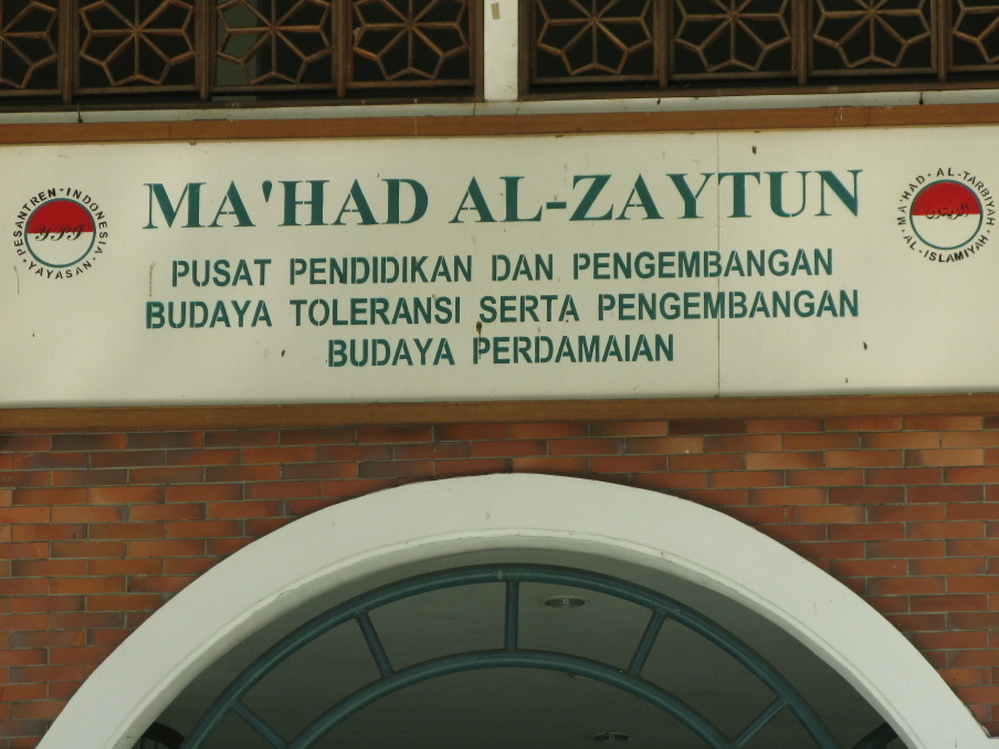 The motto on a sign above the school's door emphasizes "toleransi" or  tolerance toward people of other ethnic and religious groups.