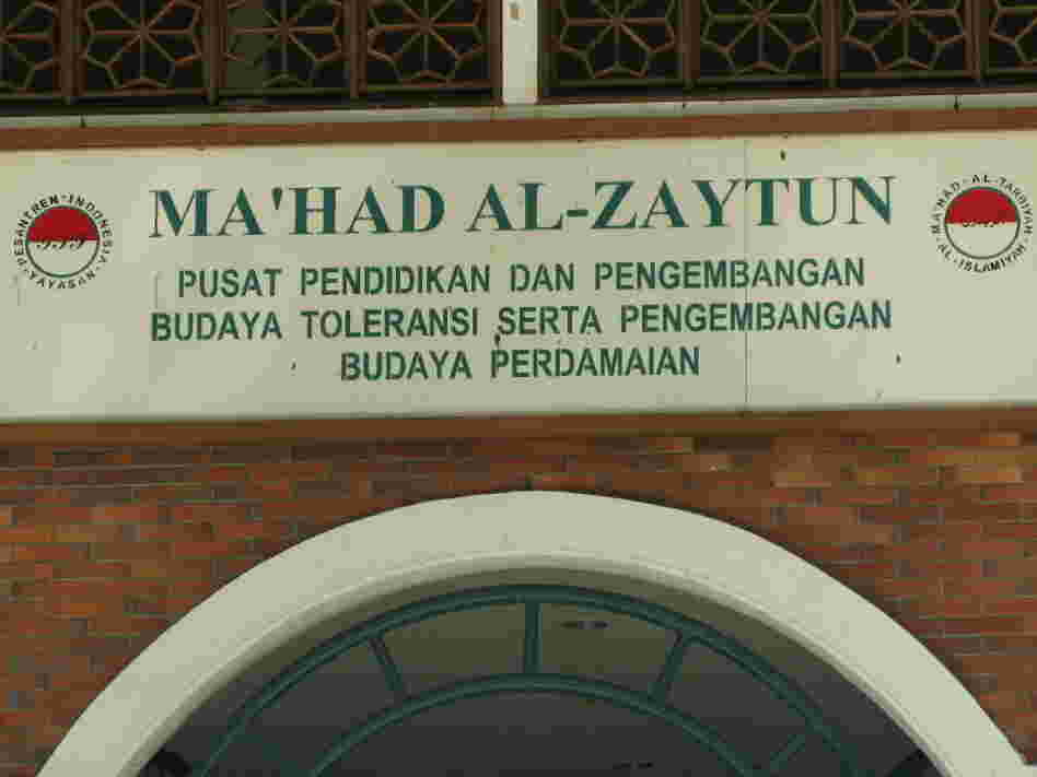 The motto on a sign above the school's door emphasizes "toleransi" or  tolerance toward people of other ethnic and religious groups.