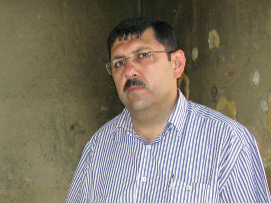 Hisham Masri, the municipality administrator in Jisr al-Shughour, stands in the military intelligence building that officials say was destroyed by armed militants. Masri says his home also was attacked and that he has  photos of the destruction on his cellphone.