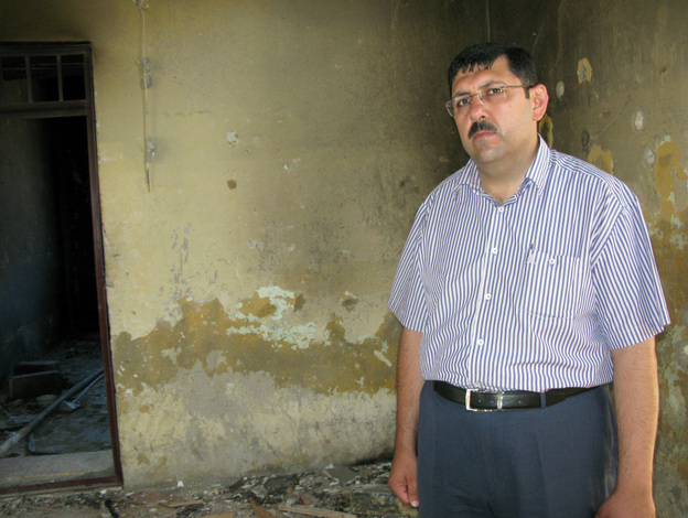 Hisham Masri, the municipality administrator in Jisr al-Shughour, stands in the military intelligence building that officials say was destroyed by armed militants. Masri says his home also was attacked and that he has  photos of the destruction on his cellphone.